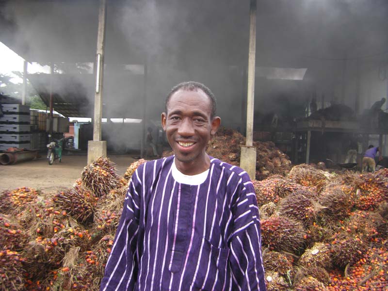 Un participant devant les fruits des palmiers à huile